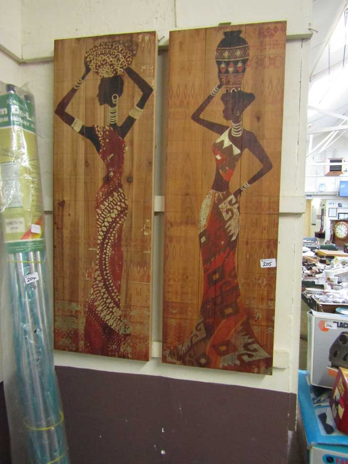 A pair of wooden wall plaques depicting African ladies