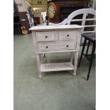 A cream painted French style cabinet having two short over one long drawer with bergere under tier