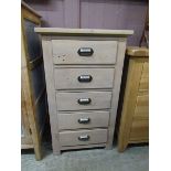 A lime washed modern pine chest of five drawers