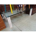 A modern plate glass rectangular table on marble effect supports