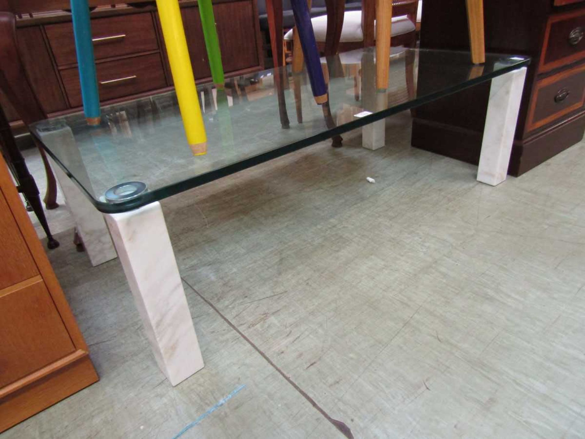 A modern plate glass rectangular table on marble effect supports