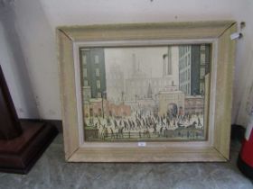 A framed Lowry print depicting bustling street scene