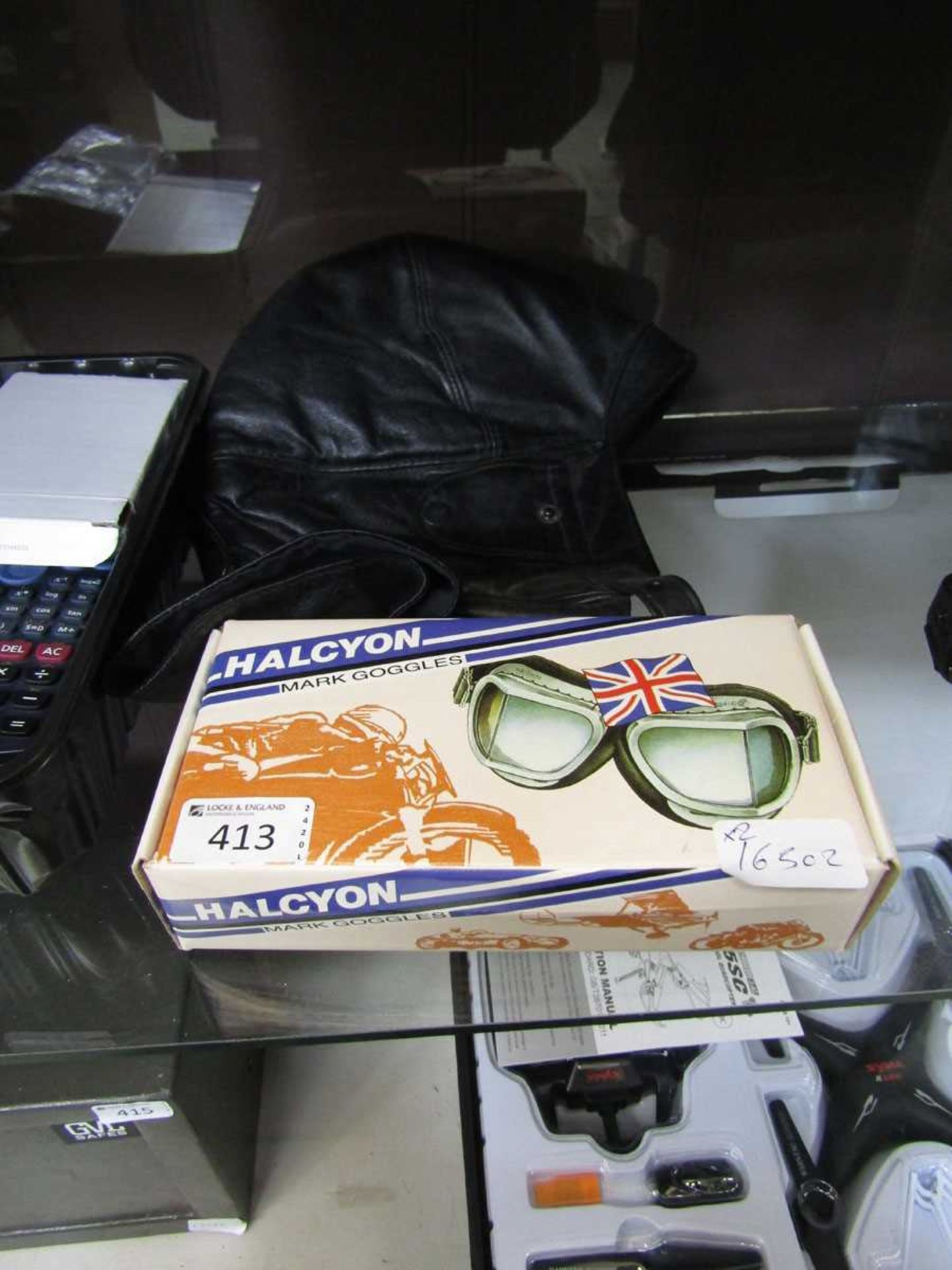 A pair of boxed goggles together with a reproduction leather flight helmet