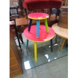A multi-coloured painted circular topped children's table with matching stool