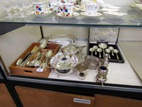 A large assortment of plated ware to include mustard pots, cream jug, sauce boat, flatware, etc