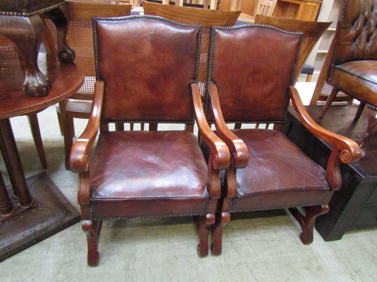 A pair of French style mahogany framed open chairs upholstered in a tan leather with studded