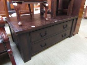 A reproduction rough cut wooden centre table having two drawers to base