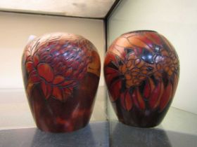 A pair of floral decorated carved wooden pots with metal liners