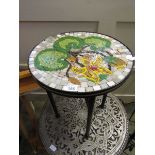 A mosaic style circular topped table on metal base