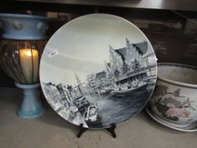 An early 20th century grey ground ceramic charger depicting canal scene