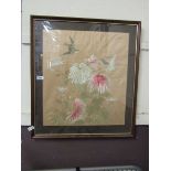 A framed and glazed needlework under glass of birds and flowers