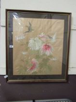 A framed and glazed needlework under glass of birds and flowers