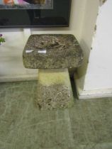 A weathered stoneware birdbath in the form of a staddle stone