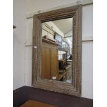 A reproduction limed framed carved rectangular wall mirror