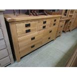 A modern oak dresser base having an assortment of six drawers above four larger drawers