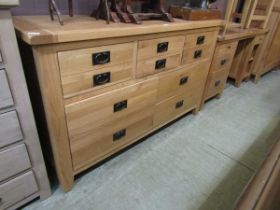 A modern oak dresser base having an assortment of six drawers above four larger drawers