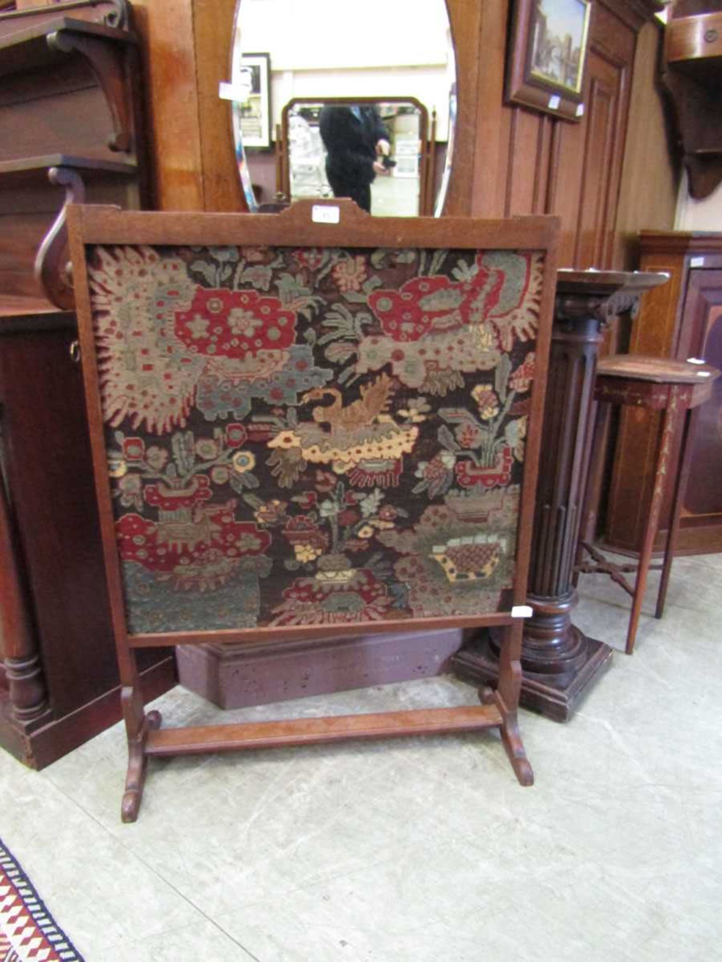 A late Victorian oak framed fire screen having a needlework to front