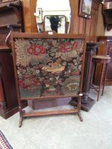 A late Victorian oak framed fire screen having a needlework to front