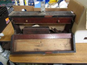 A wooden carpenter's chest containing various tools