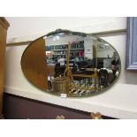 A mid-20th century oval bevel glass wall mirror