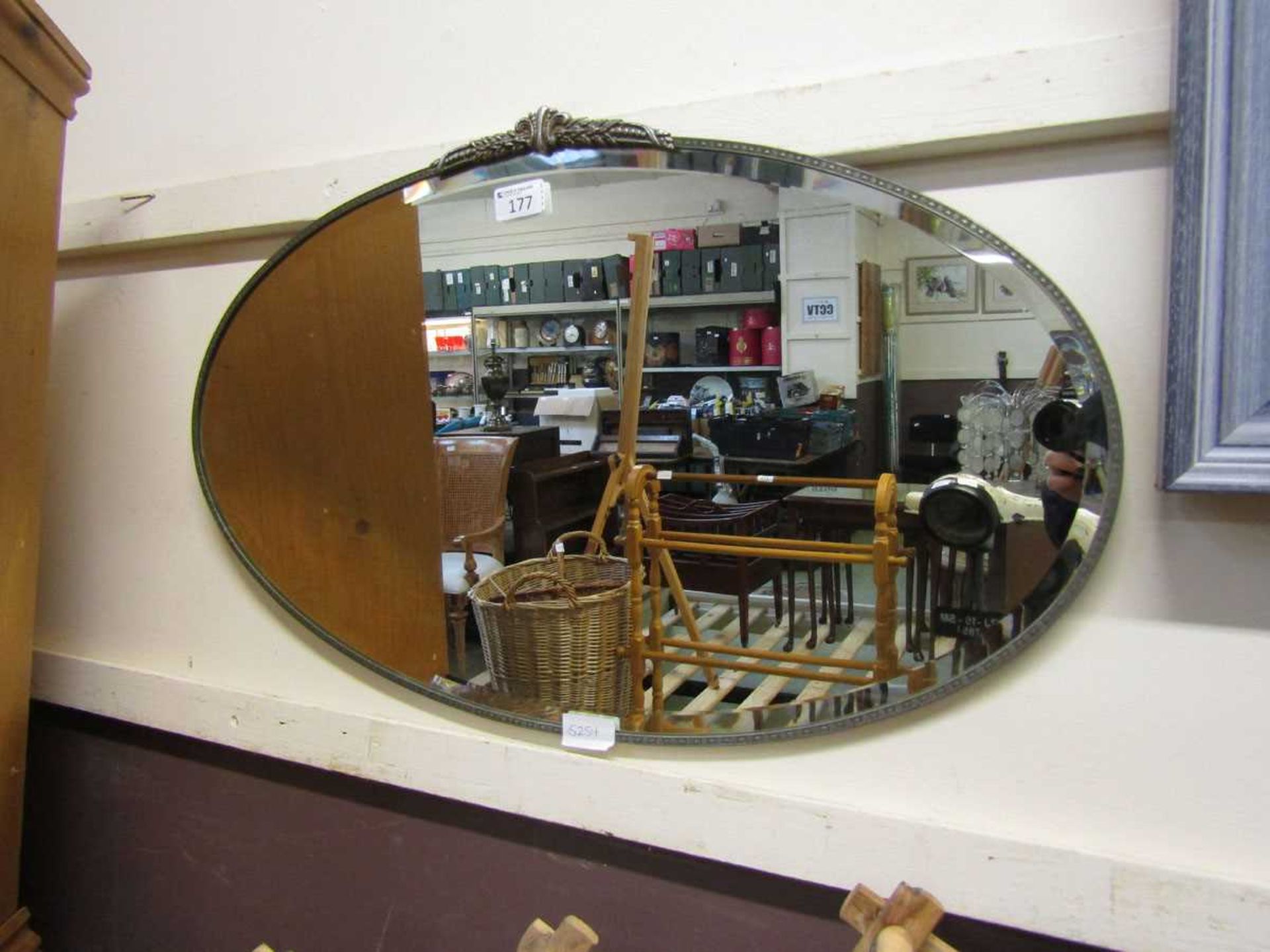 A mid-20th century oval bevel glass wall mirror