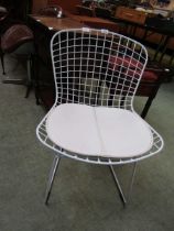 A modern copy of a white Eames chair inspired by Harry Bertoia