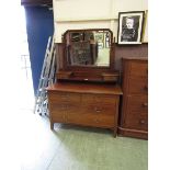 An Edwardian mahogany inlaid dressing chest having swing mirror with trinket drawers to top, the