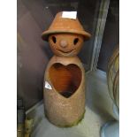 A terracotta garden ornament in the form of a man with heart shaped hole in chest