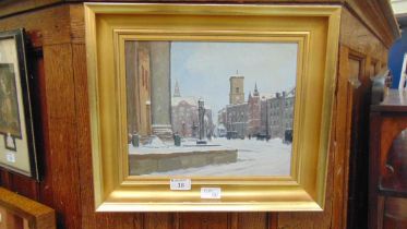 A framed oil on board of a snowy town scene