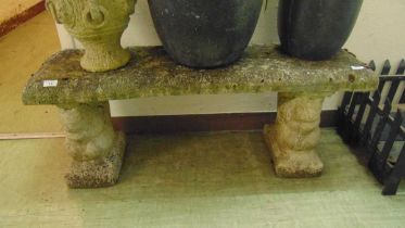 A weathered concrete garden bench with squirrel design supports, approx 45cm