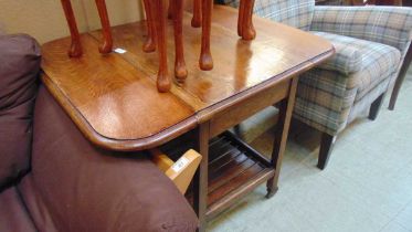 A mid-20th century oak drop leaf tea trolley with slatted under tier approx 66cm