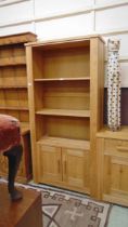 A modern oak effect full height bookcase with open storage above two cupboard doors approx 185cm