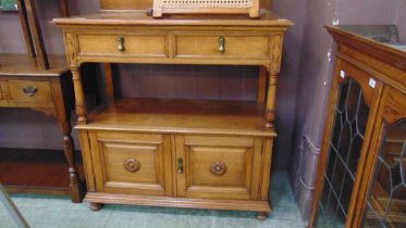 A mid-20th century oak buffet having raised back section with two drawers to top over open storage