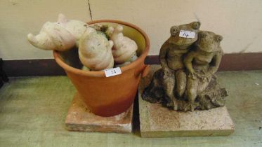 A ceramic planter together with gnomes and a weathered garden ornament of frogs