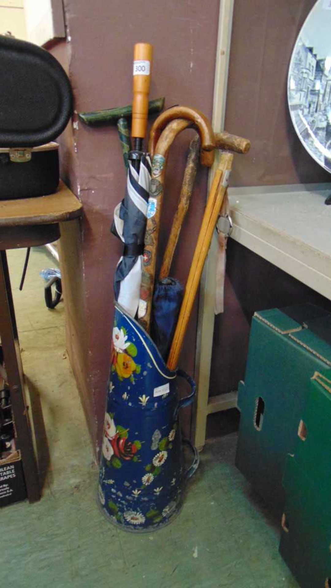 An assortment of walking sticks and umbrellas in a painted barge ware style coal scuttle