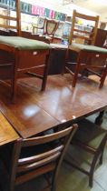 A mid-20th century oak drawer leaf table with a set of four similar chairs