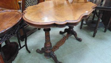 A Victorian walnut topped table on to turned supports with crossmember