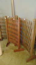 Three weathered wooden extending trellis stands