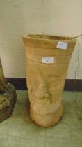 A clay planter with Easter Island head style decoration
