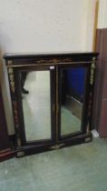 A Victorian gilt and ebonised cabinet with a pair of mirrored doors