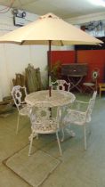 A white painted aluminium garden table with a set of four matching open armchairs and a modern