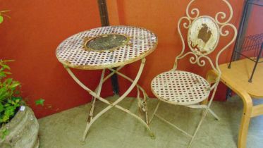A folding distressed metal garden bistro table with a single matching chair