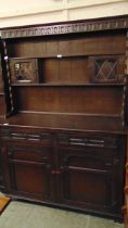 A mid-20th century stained oak dresser having plate rack to top, the base having two drawer above