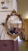 An ornate gilt framed wall mirror with cherub design