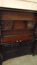 A mid-20th century dark oak dresser having raised plate rack to top, the base having two drawers