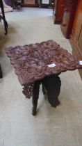 An early 20th century carved leaf design occasional table with removable top and collapsible base