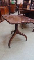 A late Victorian mahogany walnut tilt top table on brass castors