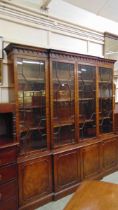 A reproduction mahogany break front bookcase cabinet having four glazed doors to top, the base