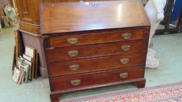 A George III mahogany bureau, the interior fitted with pigeon holes and drawers, above four oak