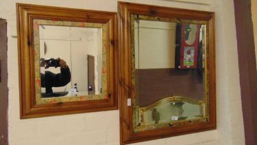 A large pine framed rectangular bevel glass mirror with floral decoration together with a similar